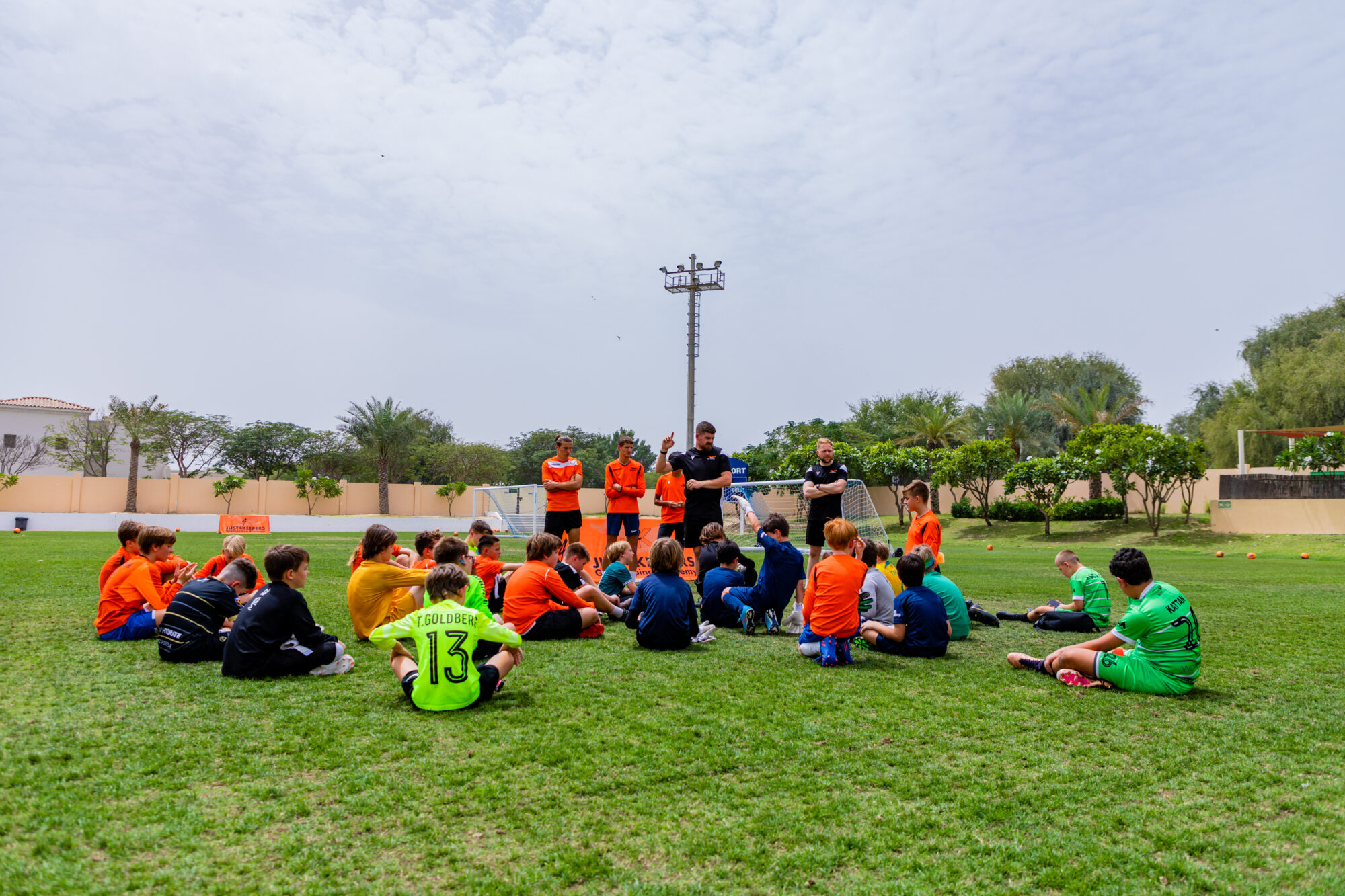 Group of children sat on a football pitch